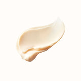 A single, thick swirl of creamy, pale peach lotion, with a slightly glossy sheen, isolated against a white background.