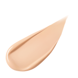 A pear-shaped swipe of light-colored liquid foundation, slightly thicker at one end and tapering to a point, against a white background.