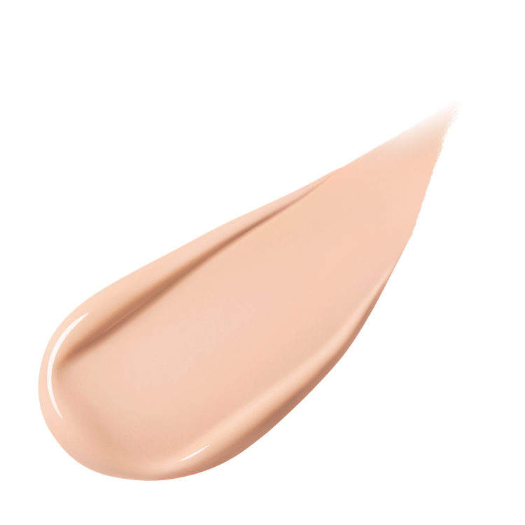 A pear-shaped swipe of light-colored liquid foundation, slightly thicker at one end and tapering to a point, against a white background.