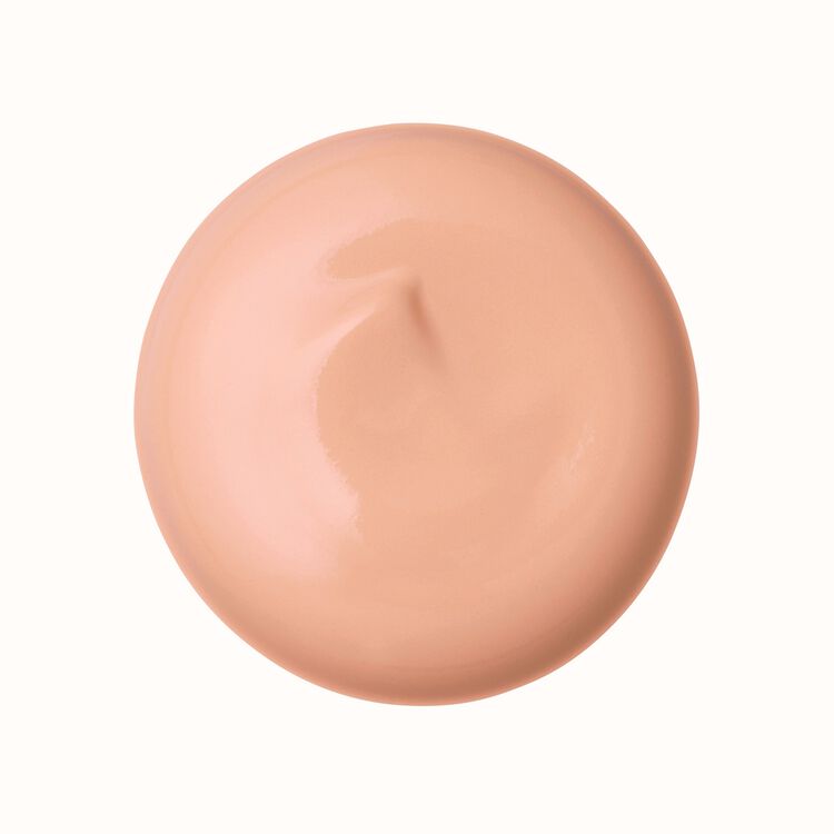 Circular swatch of light peach-beige cream foundation makeup.
